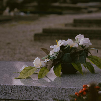 a wreath of white flowers placed on a grave