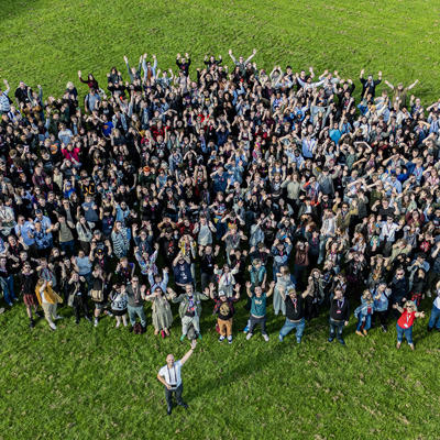 An aerial photo of a large group of people with their hands in the air