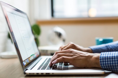 Someone's hands typing on a laptop computer 