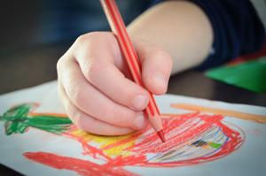 A child's hand doing a drawing