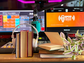 Headphones in front of a computer screen with the EPOD conference logo