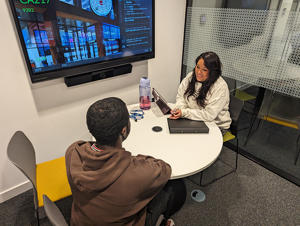 A student being interviewed at a table by a woman